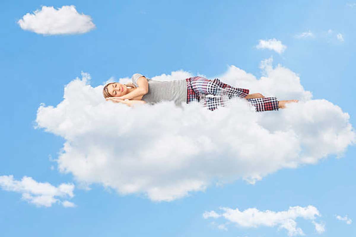 Uma mulher dormindo e sonhando com nuvens.